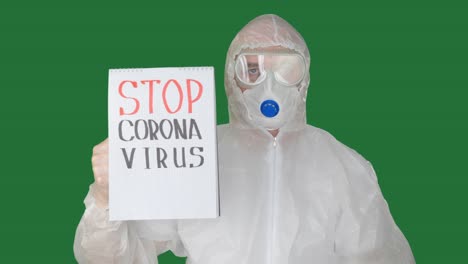 bio engineer in protective mask and suit showing clip board with stop coronavirus sign. man in safety costume warning about dangerous 2019-ncov virus on clip board. world coronavirus quarantine.