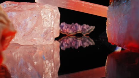 Close-up-macro-shot-of-beautiful-shiny-rough-quartz-and-amethyst-crystals,-on-a-black-reflective-background