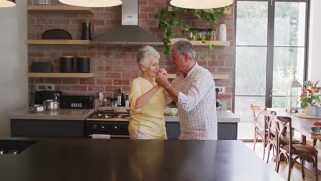 Pareja-Caucásica-Mayor-Bailando-Y-Sonriendo-En-La-Cocina