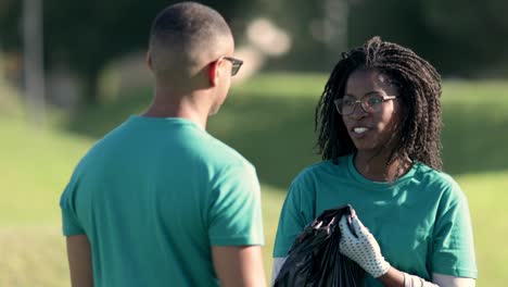 voluntarios sonrientes hablando en el parque