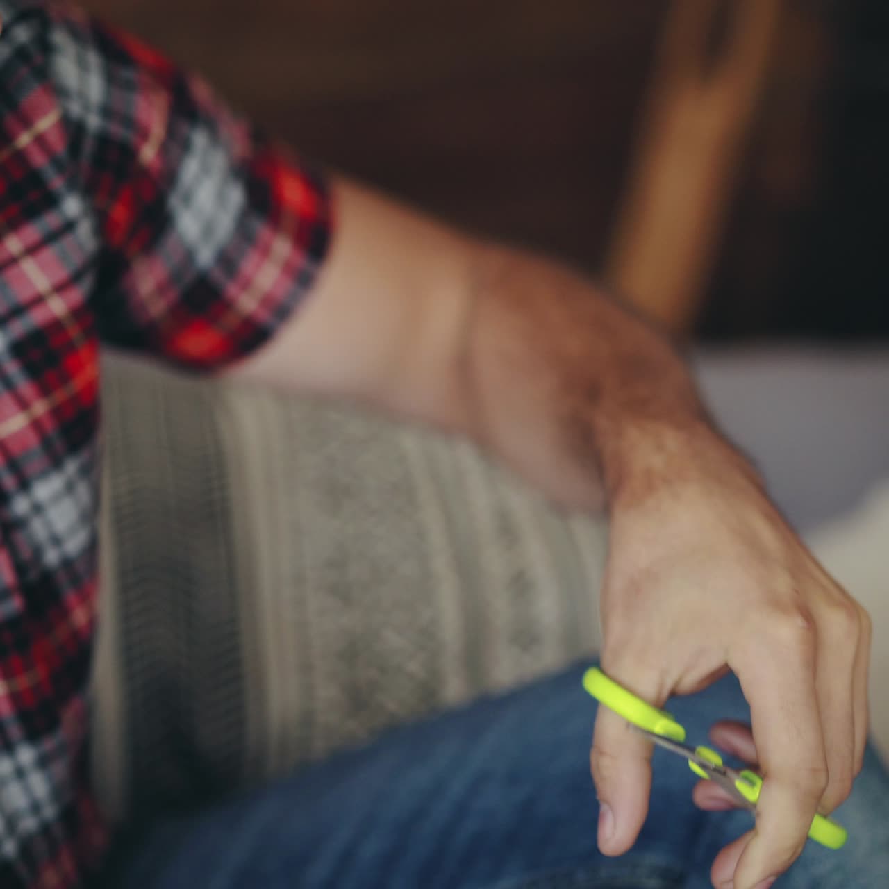 man is cutting heart from colored paper by scissors on Valentine's Day near sweetheart