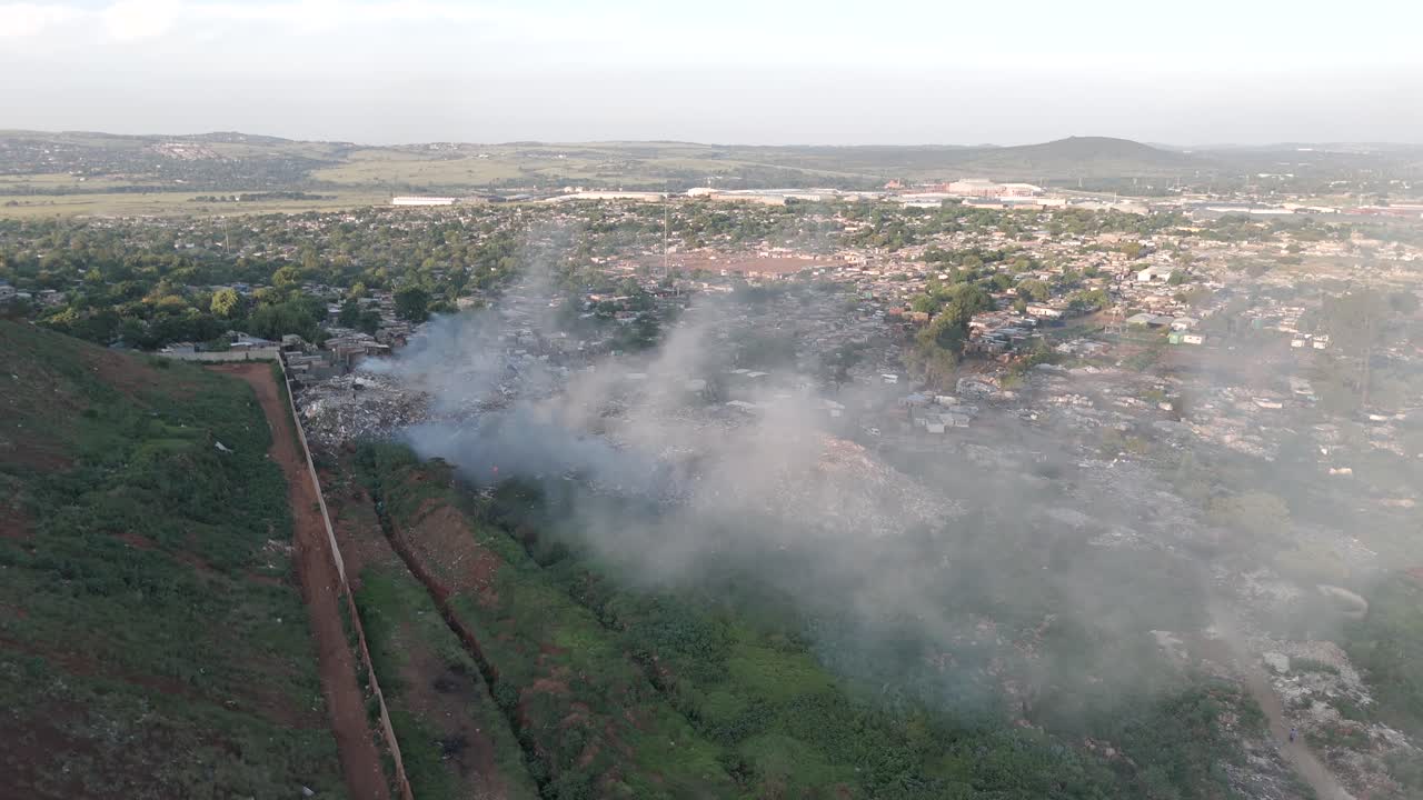 las cautivadoras imágenes aéreas de 4k presentan una toma dinámica de un dron empujado, revelando sin problemas un pueblo rural situado en el borde de una planta de procesamiento de residuos que quema residuos en sudáfrica.