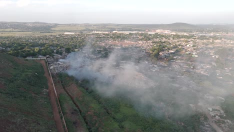las cautivadoras imágenes aéreas de 4k presentan una toma dinámica de un dron empujado, revelando sin problemas un pueblo rural situado en el borde de una planta de procesamiento de residuos que quema residuos en sudáfrica.
