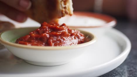 un pequeño tazón de salsa roja en un plato blanco