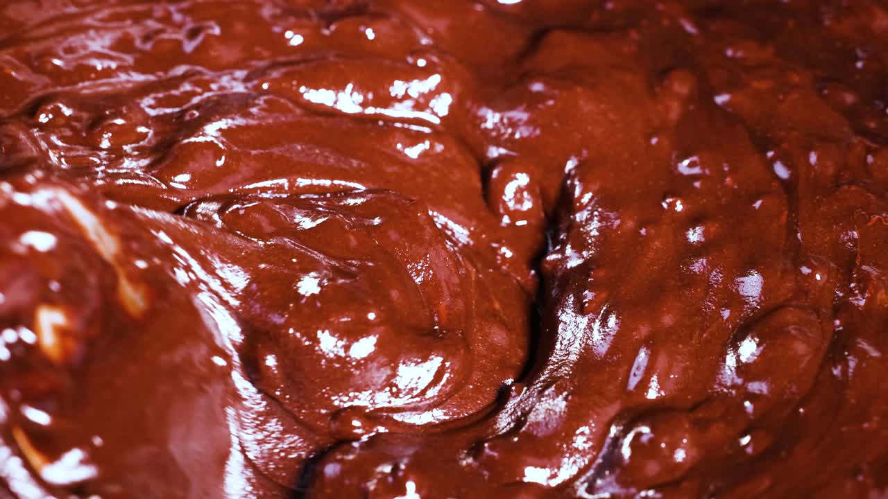Spoon stirring thick, glossy chocolate batter