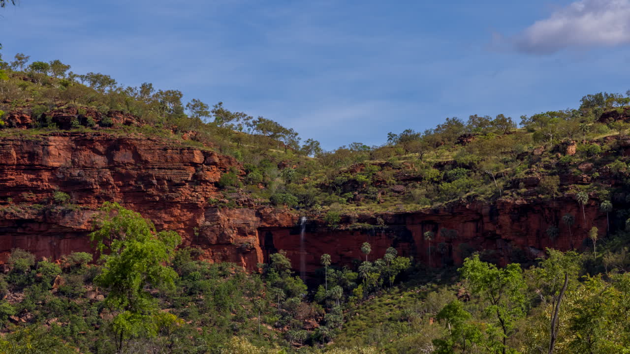 lapso de tiempo de una pequeña cascada que fluye sobre una montaña con nubes en el territorio del norte