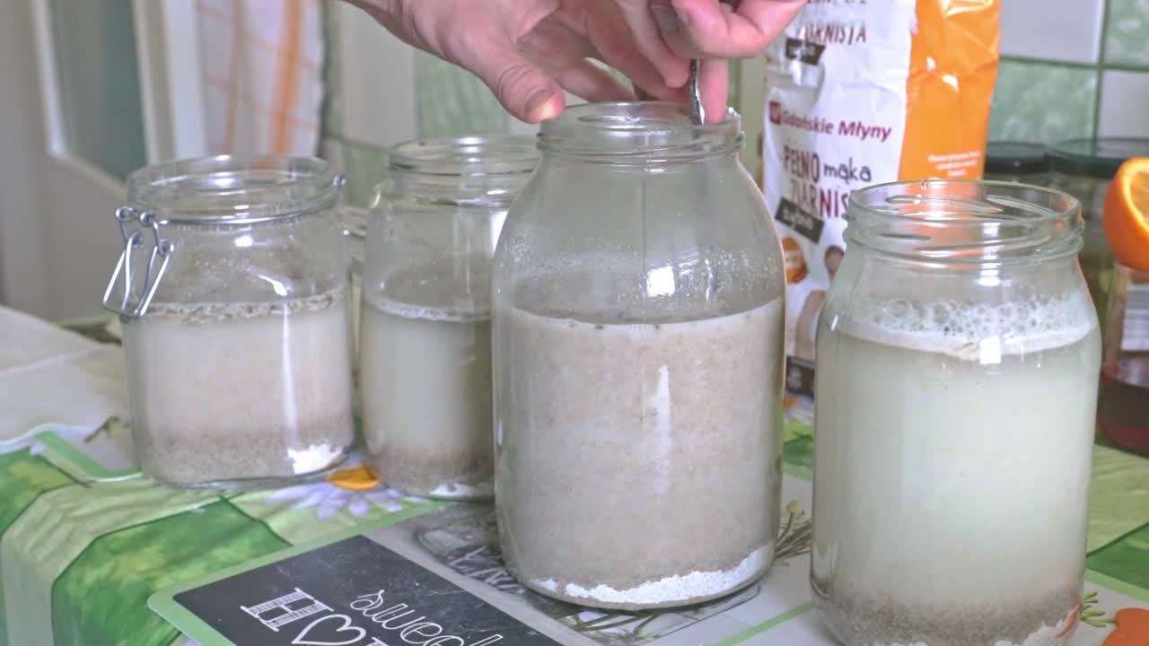 큰 병에 사워도우를 섞어 박테리아 기반 수프 베이스를 만듭니다.