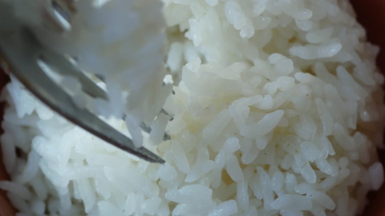 primer plano de arroz blanco cocido con un tenedor