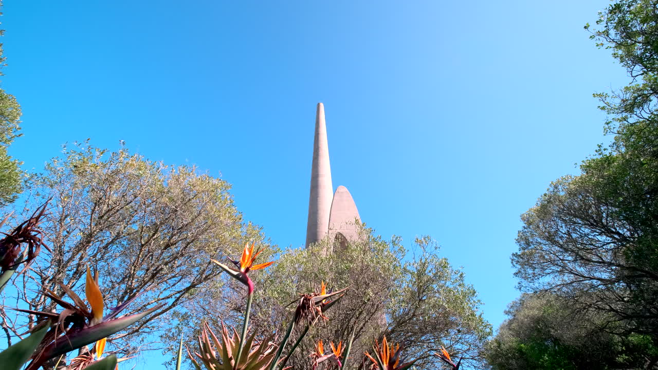 Upward view over trees and bird of paradise flower of Afrikaanse Taalmonument
