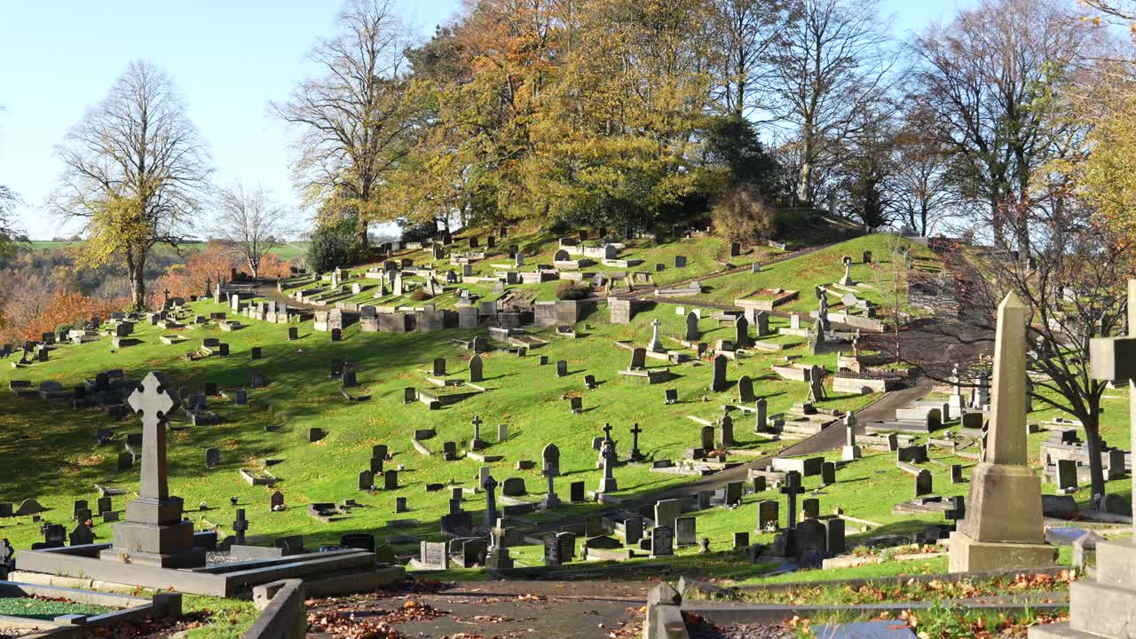 Cemetery landscape with gravestones on hillside. English countryside graveyard