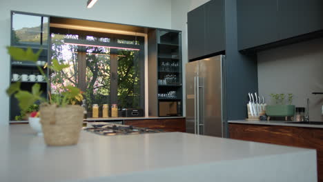 modern kitchen with stainless steel appliances and large windows overlooking garden, copy space