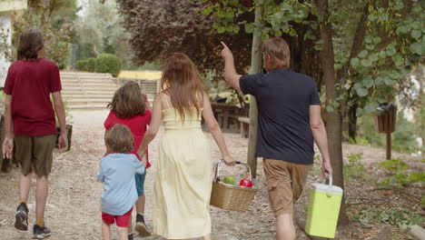 Back-view-of-happy-Caucasian-family-choosing-place-for-picnic-in-the-forest