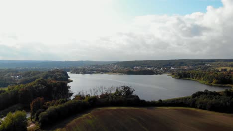 aerial pan shot meadow and lake in kolbudy, pomeranian district in poland