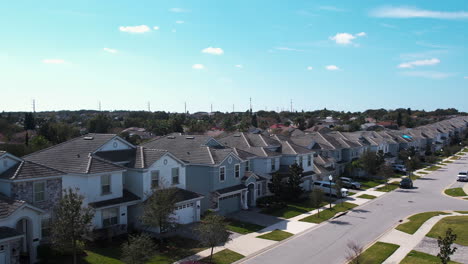 aerial view rising behind palm trees revealing houses in a neighborhood of orlando, sunny day in florida, usa