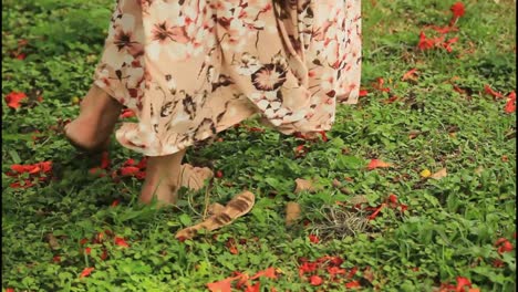 mujer caminando descalza en un jardín
