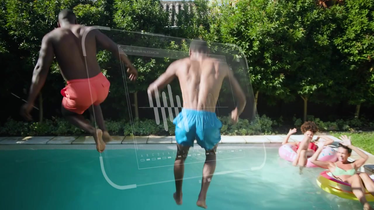 Two shirtless men pointing then sprinting hand-in-hand and leaping into pool, soaking friends