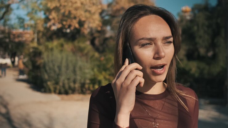 Giovane donna che usa lo smartphone all'aperto.