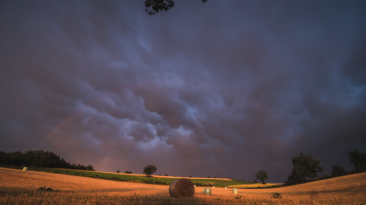 time lapse at sunset with a rainbow after a thunderstorm with a beautiful sky in the countryside in France