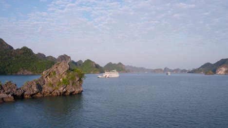 cruise ships at ha long bay tour sailing by karst rock mountains in vietnam
