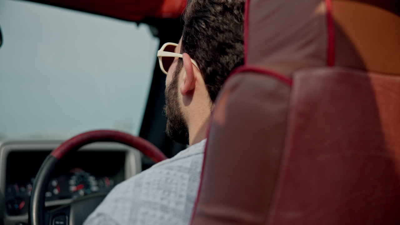 hombre conduciendo un coche descapotable