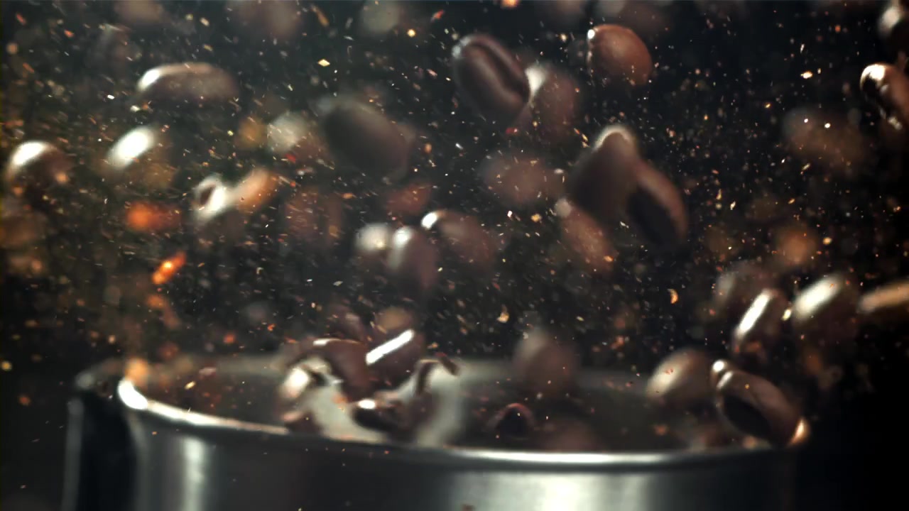 Movimento rallentato di chicchi di caffè che cadono in un macinacaffè