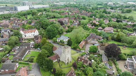 a charming english village with historic buildings and lush greenery in milton keynes, aerial view