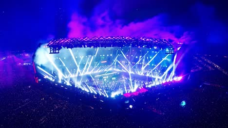 los músicos que actúan en el escenario crean una atmósfera electrizante con un impresionante espectáculo de luces para una multitud entusiasta.