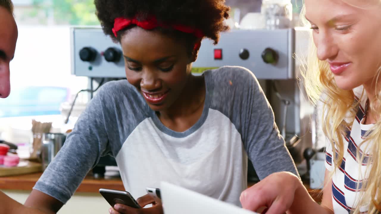 Group of friends using mobile phone and laptop