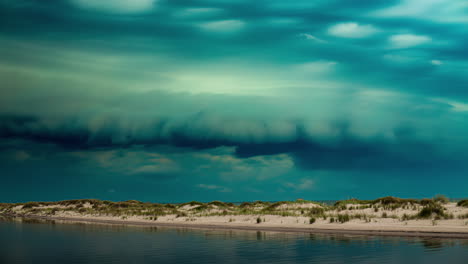 dramatic storm clouds over sandy dunes and water