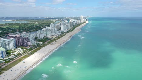 drone view along collins avenue in miami, revealing modern hotel buildings that line the ocean front, offering stunning water views