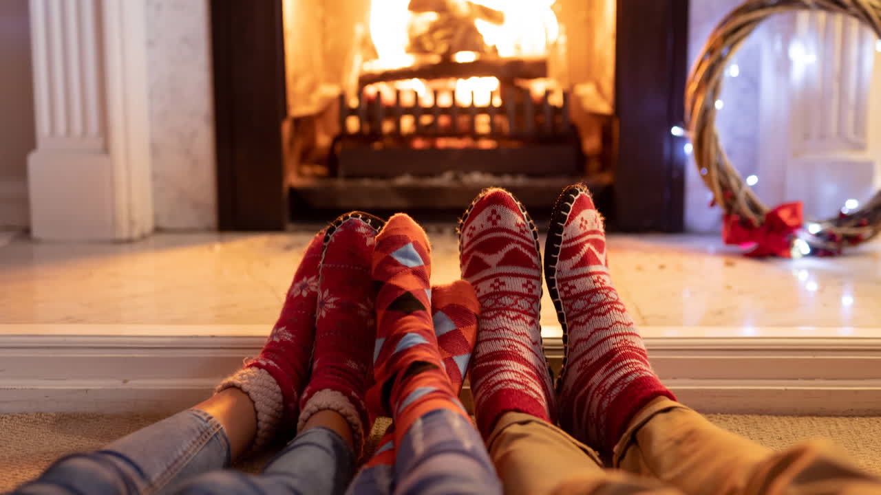animación de los pies de una familia afroamericana en calcetines de navidad descansando frente a la chimenea