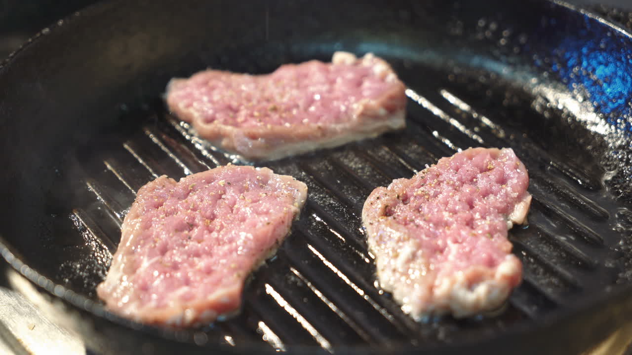 Seasoned sirloin steak in griddle pan.