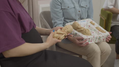 pregnant woman holding toy baby