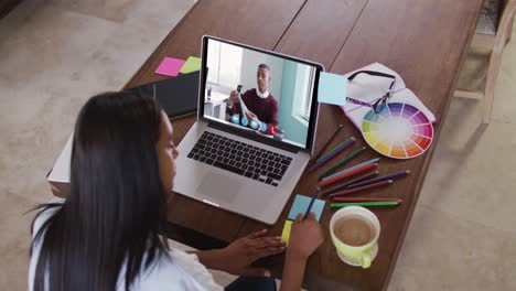 Mujer-Caucásica-Usando-Una-Computadora-Portátil-En-Una-Videollamada-Con-Un-Colega-Masculino,-Tomando-Notas