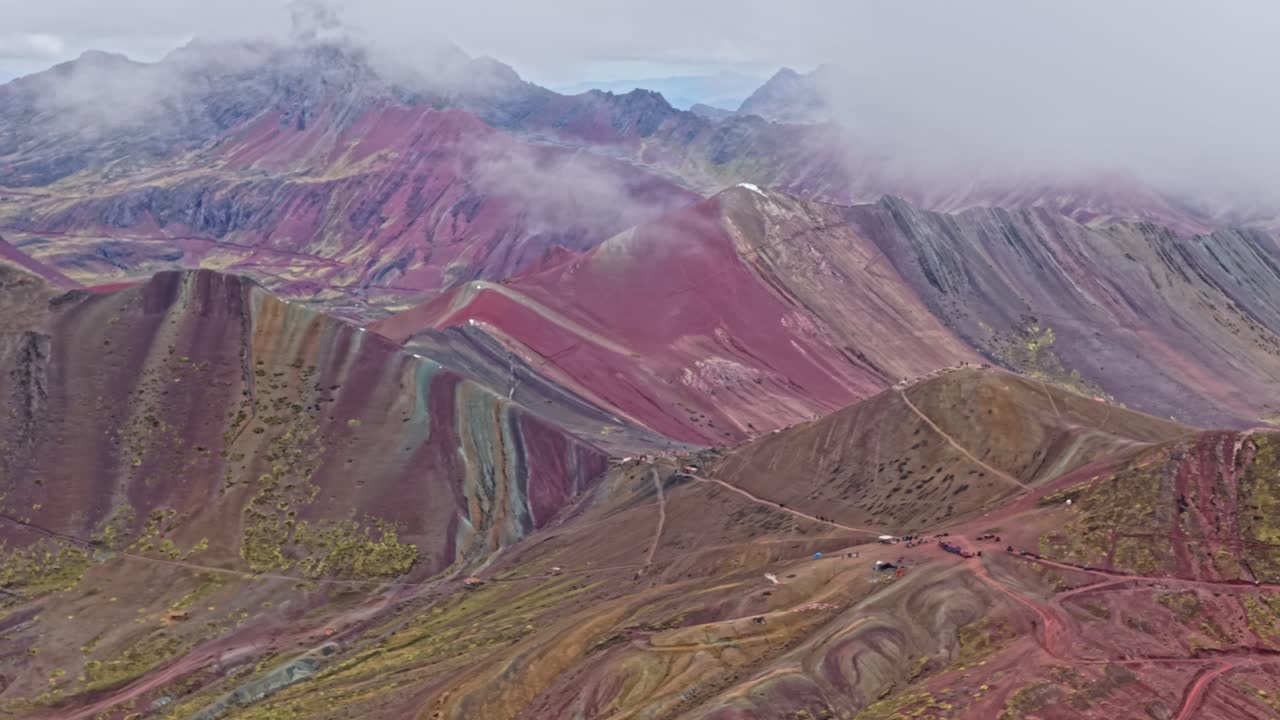 Panoramic view of Rainbow Mountain's colorful peaks in rustic Peru