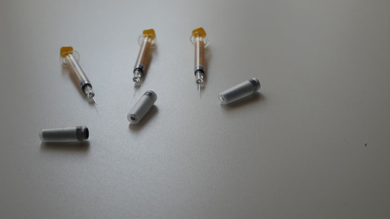 Syringes scattered on a table, evoking clinical precision and care