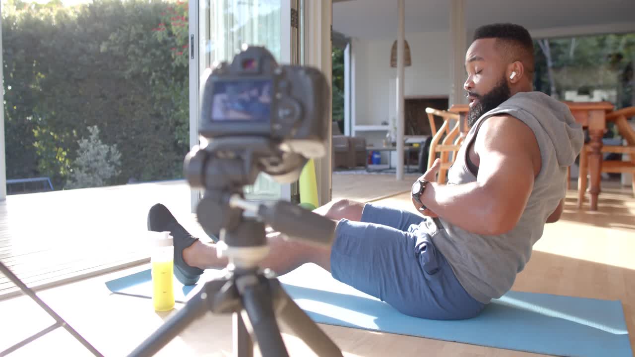 vlogger de fitness afroamericano aconsejando y filmando en casa, cámara lenta