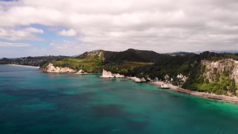 Aerial-scenery-of-New-Zealand-seaside,-Hahei-Beach,-Cathedral-Cove,-Te-Hoho-Rock,-popular-tourist-destination,-Coromandel-Peninsula