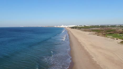 aerial shot of slow motion waves on a beach in the algarve, portugal