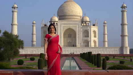 woman in red sari posing at the taj mahal