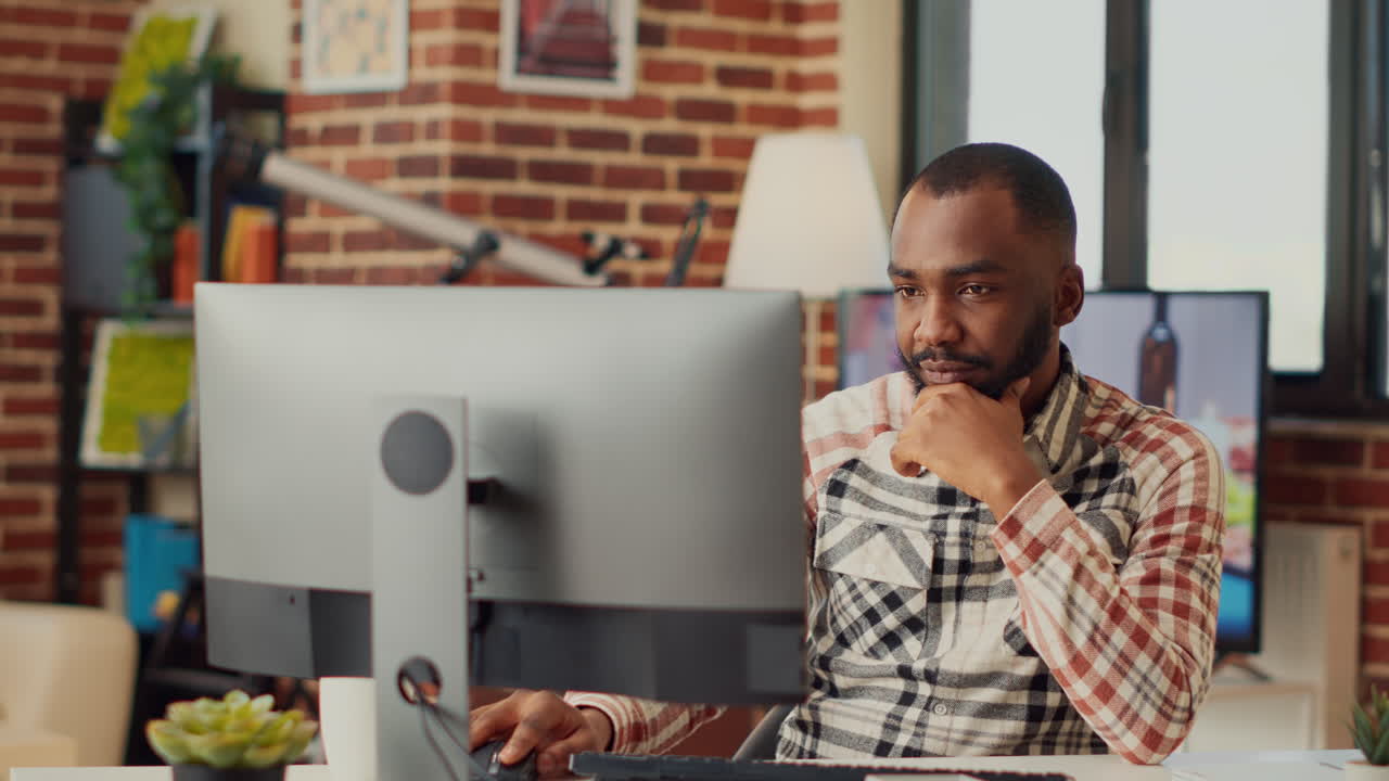 Afroamerikansk mand, der arbejder hjemmefra på computer