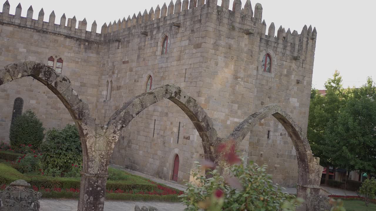 Santa Bárbara Garden in Braga, Portugal, featuring medieval stone arches and a historic castle backdrop