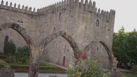 santa bárbara garden in braga, portugal, featuring medieval stone arches and a historic castle backdrop