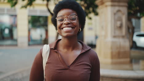 carefree curly girl sincerely smiling at camera having a good mood