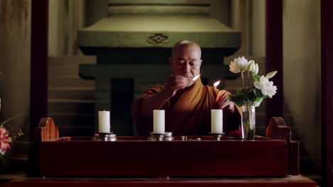 monk lighting candles in a temple ceremony