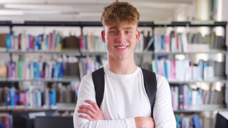 portrait of male student standing in college library