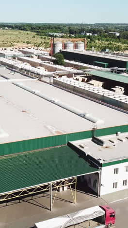aerial view of the woodworking factory outside the city. camera motion to backwards vertical video