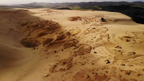 Paisaje-Dramático-Del-Desierto-De-Arena-Dorada,-Contraste-Con-Las-Verdes-Colinas-Aéreas