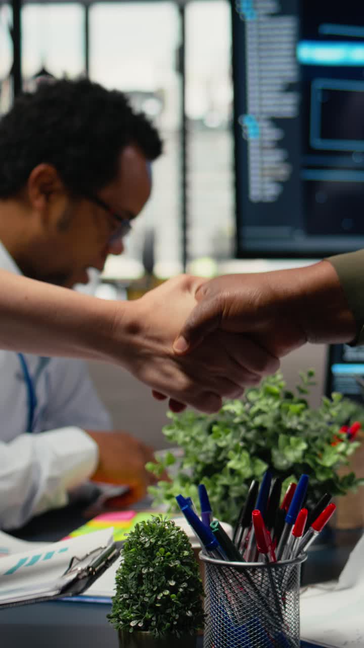 Vertical video Programmer shaking hand with businessmen in tech agency boardroom
