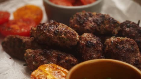 chef sirviendo verduras a la parrilla y carne en la mesa con salsa